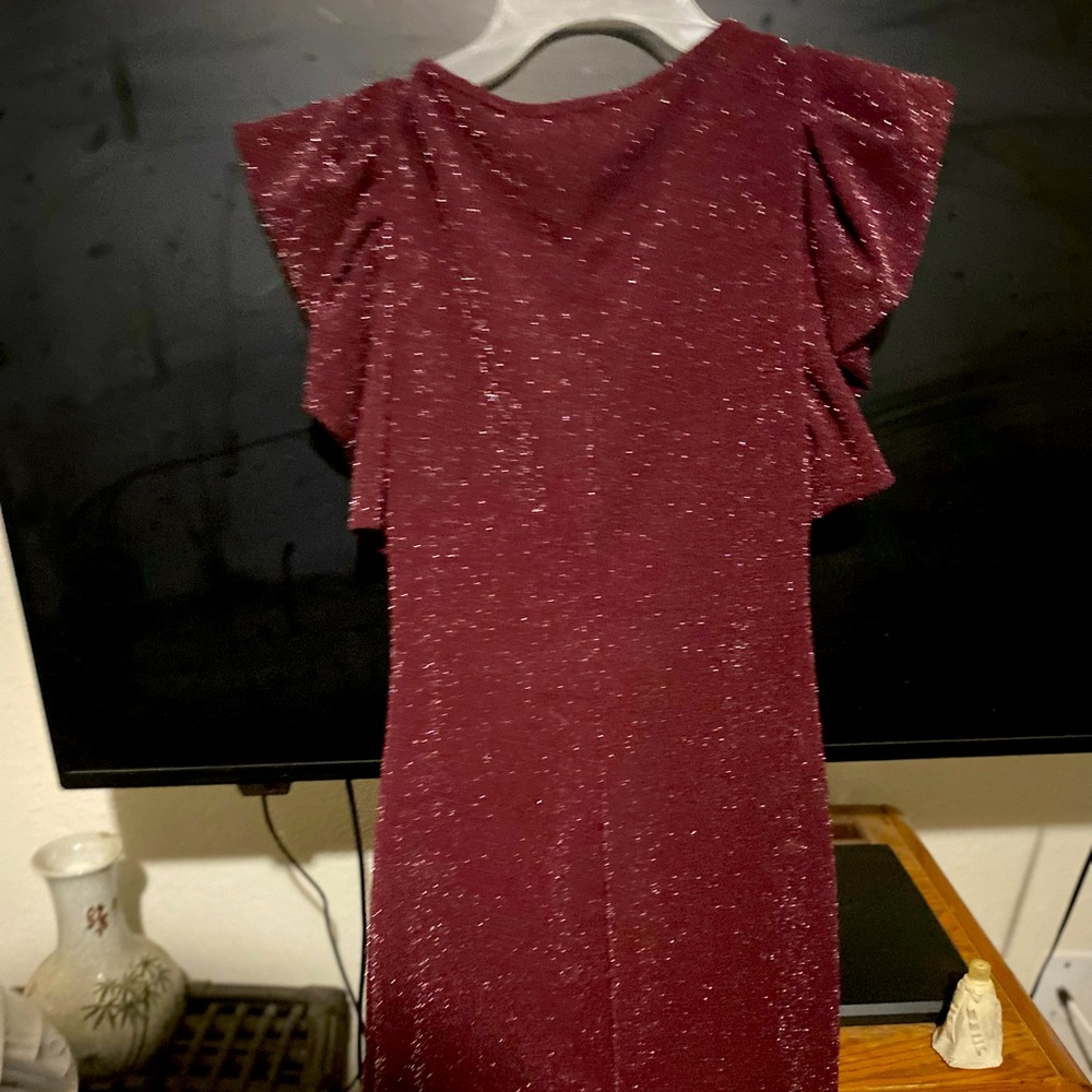 And Dark Maroon Sparkly Dress with pointed shoulders and flare like ruffles.